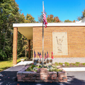 veteran memorial structure and plaque with American flag above